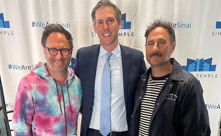 Rabbi Shermon in the middle of two other men